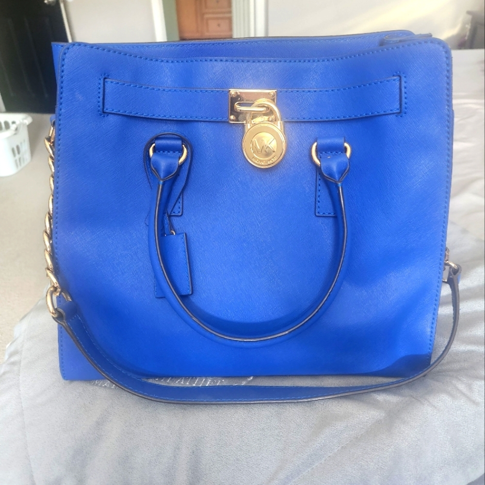 (d) Michael Kors Blue Satchel with Gold Accents.